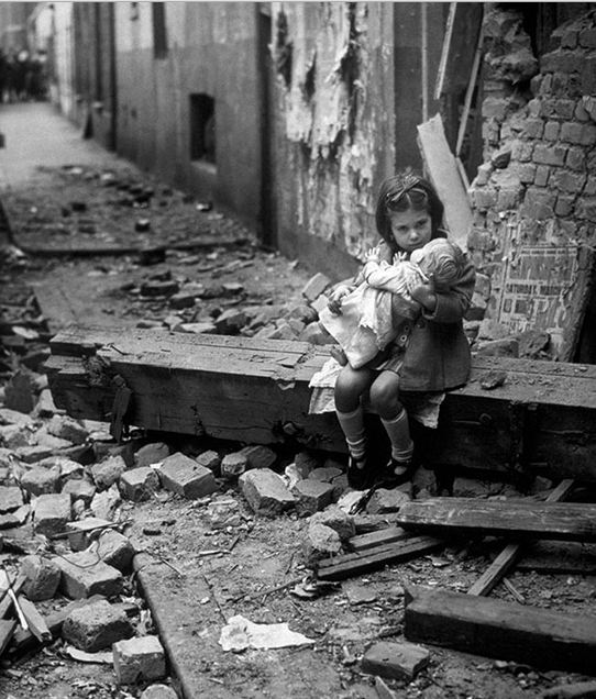 فتاة صغيرة تجلس مع دميتها على انقاض منزلها الذي دمر في لندن 1940