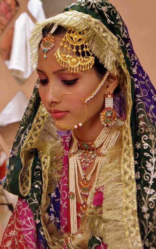 الذهب والمجوهرات العتيقة مع ماكياج بسيط يجعل العروس تبدو أنيقة