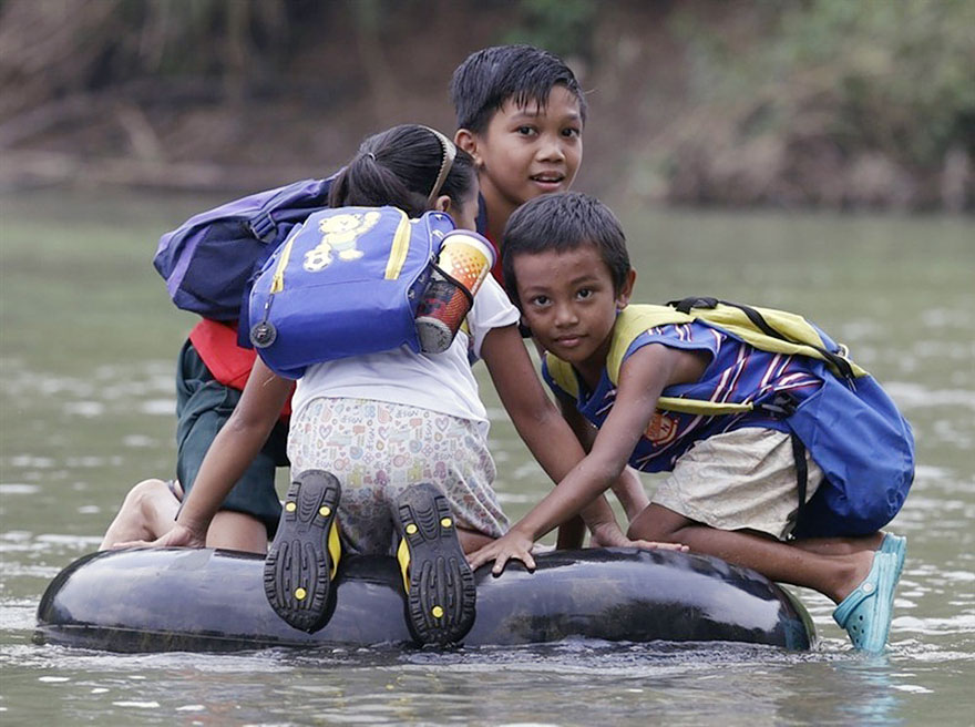 يقطعون النهر بواسطة إطارات السيارات في الفلبين
