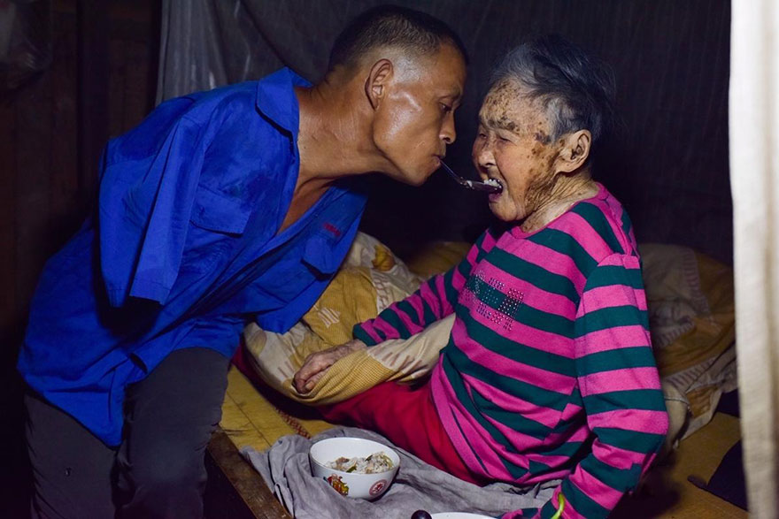 ابن بدون يدين يطعم أمه المشلولة بفمه