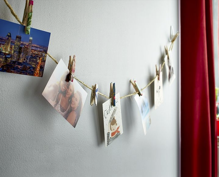تعليق بعض الصور على الحائط بواسطة بعض الحبال