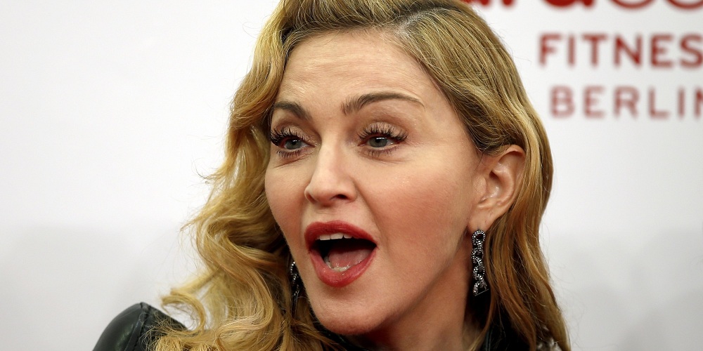 U.S. pop star Madonna speaks during her visit at the "Hard Candy Fitness" center in Berlin, Germany, Thursday, Oct. 17, 2013. (AP Photo/Michael Sohn)