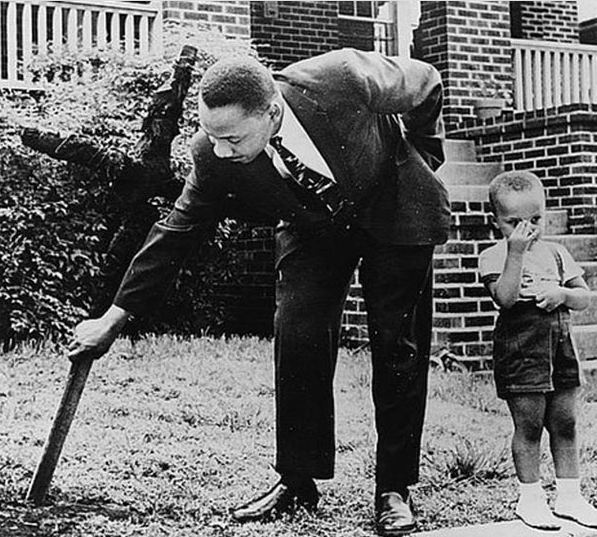 مارتن لوثر كينغ مع ابنه يزيل صليب محترق في فناء منزله الامامي 1960